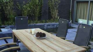 houten tuintafel met ijzeren stoelen, hovenier Tilburg en omstreken Breda Eindhoven Vught